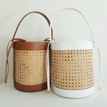 Lataa kuva Galleria-katseluun, Tyylikäs ja tilava ASYA Bucket nahkalaukku raffiareunalla ja polyesterivuorella. Laukussa hyvin tilaa isomallekkin tavaralle. Koko: 20 cm halkaisija, 24 cm korkeus Olkahihnan leveys 1,5 cm, pituus 103 cm Materiaali: nahka/ raffia/ polyesterivuori Valmistusmaa: Italia