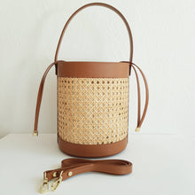 Lataa kuva Galleria-katseluun, Tyylikäs ja tilava ASYA Bucket nahkalaukku raffiareunalla ja polyesterivuorella. Laukussa hyvin tilaa isomallekkin tavaralle. Koko: 20 cm halkaisija, 24 cm korkeus Olkahihnan leveys 1,5 cm, pituus 103 cm Materiaali: nahka/ raffia/ polyesterivuori Valmistusmaa: Italia