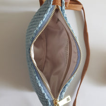 Lataa kuva Galleria-katseluun, Tyylikäs CARA laukku rannehihnalla ja säädettävällä nahkaisella olkahihnalla. Sisällä kaunis satiini vuori ja vetoketjullinen sivutasku. Materiaali: raffiapalmu/ nahka/ polyesteri. Väri: vaaleansininen. Koko: pituus 22,5 cm, korkeus 17 cm. Hihnan leveys 2 cm ja max pituus 122 cm. Valmistusmaa: Italia.