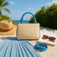 Lataa kuva Galleria-katseluun, Tyylikäs PAULA olkalaukku, päällinen raffia palmua, kahva ja hihna nahkaa. Punottu raffia-pinta kantaa mukanaan auringon lämpöä ja rantakatujen tunnelmaa, kun taas nahkaiset yksityiskohdat viimeistelevät tyylin.
