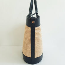 Lataa kuva Galleria-katseluun, Tyylikäs EVELIINA kesälaukku mihin mahtuu kaikki tarvittavat tavarat. Laukussa on yksi iso tasku ja vetoketjullinen piilotasku, sekä tekstiilikangasvuori. Metalliosat ovat kullanväriset. Väri: valkoinen ja musta Materiaali: nahka, raffia Koko: 45 cm x 31 cm x 15 cm Hihnan max pituus 120 cm Valmistusmaa: Italia