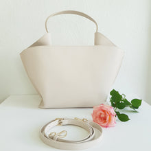 Lataa kuva Galleria-katseluun, Kaunis LIV laukku muodostuu kahdesta tilavasta osiosta. Sisällä laukussa on vetoketjullinen sisätasku ja toisella puolella puhelintasku. Kullanväriset metalliosat ja magneettilukitus. Ainutlaatuiset valmistusmateriaalit antavat laukulle kestävyyttä ja samalla myös ympäristöystävällisyyttä. Hihnan max pituus 120 cm Koko: 42 cm x 25 cm x 15 cm Materiaali: 58% kierrätysnahkaa, 25% polyesteria, 17% polyuretaania Valmistusmaa: Italia