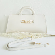 Lataa kuva Galleria-katseluun, ALIINA nahkalaukku – italialaista eleganssia. Minimalistinen mutta huomiota herättävä nahkalaukku, jossa yhdistyvät käytännöllisyys ja klassinen tyyli. Laukun etuosaa koristaa näyttävä kullanvärinen solkiyksityiskohta, joka tuo kokonaisuuteen ripauksen ylellisyyttä.