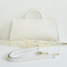 Lataa kuva Galleria-katseluun, ALIINA nahkalaukku kantokahvoilla ja säädettävällä olkahihnalla. Edestä laukkua koristaa kaunis kullanvärinen solkiyksityiskohta.