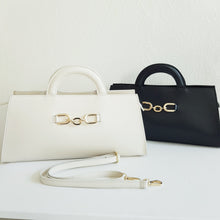 Lataa kuva Galleria-katseluun, ALIINA nahkalaukku kantokahvoilla ja säädettävällä olkahihnalla. Edestä laukkua koristaa kaunis kullanvärinen solkiyksityiskohta.