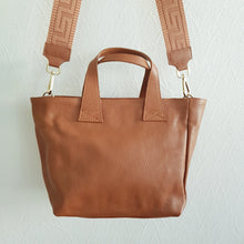 Lataa kuva Galleria-katseluun, Upea TESSA nahkalaukku, säädettävällä koristehihnalla ja kulta lukoilla. Laukussa vetoketjulukitus. Sisältä löytyy avo ja vetoketjullinen piilotasku. Koko: pituus 37 cm, korkeus 22 cm, syvyys 15cm Olkahihna leveys 1,5 cm, max pituus 128 cm leveä koristeellinen polyesteri/ nahka hihna kullanvärisillä pistolukoilla, leveys 5,5 cm, säädettävä pituus max. 128 cm Valmistusmaa Italia