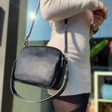 Lataa kuva Galleria-katseluun, Tyylikäs ja tilava ALEXA nahkalaukku kolmella hihnalla. Laukussa on kaksi vetoketjullista taskua ja keskellä avotasku magneettilukituksella. Väri: luonnonvalkoinen ja musta. Koko: pituus 23 cm, korkeus 20 cm, syvyys 10 cm- Valmistusmaa: Italia