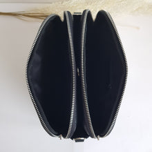 Lataa kuva Galleria-katseluun, Tyylikäs ja tilava ALEXA nahkalaukku kolmella hihnalla. Laukussa on kaksi vetoketjullista taskua ja keskellä avotasku magneettilukituksella. Väri: luonnonvalkoinen ja musta. Koko: pituus 23 cm, korkeus 20 cm, syvyys 10 cm- Valmistusmaa: Italia