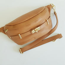 Lataa kuva Galleria-katseluun, Upea tyyliltään ja käytännöllinen kooltaan ALICE crossbody vyö-olkalaukku. Laukussa on säädettävä hihna, kullanväriset metalliosat, vetoketjulukitus, edessä kultainen koristelukko ja takana vetoketjullinen tasku.