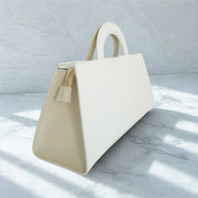 Lataa kuva Galleria-katseluun, ALIINA nahkalaukku – italialaista eleganssia. Minimalistinen mutta huomiota herättävä nahkalaukku, jossa yhdistyvät käytännöllisyys ja klassinen tyyli. Laukun etuosaa koristaa näyttävä kullanvärinen solkiyksityiskohta, joka tuo kokonaisuuteen ripauksen ylellisyyttä.