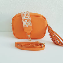 Lataa kuva Galleria-katseluun, Oranssi ANGIE olkalaukku on aitoa nahkaa. Laukussa on kaksi säädettävää olkahihnaa ja vetoketjukiinnitys. Tupsukoriste toimii vetimenä. Suosittu crossbody malli.