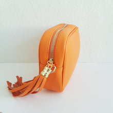 Lataa kuva Galleria-katseluun, Oranssi ANGIE olkalaukku on aitoa nahkaa. Laukussa on kaksi säädettävää olkahihnaa ja vetoketjukiinnitys. Tupsukoriste toimii vetimenä. Suosittu crossbody malli.