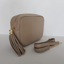 Lataa kuva Galleria-katseluun, ANGIE laukussa on säädettävä olkahihna ja vetoketjukiinnitys. Tupsukoriste toimii vetimenä. Erittäin suosittu crossbody malli.
Väri: beige
Materiaali: aito nahka
Koko: pituus 20 cm, korkeus 15 cm, syvyys 7 cm.
Kapea nahkahihna kullanvärisillä pistolukoilla, leveys 2 cm, säädettävä pituus 130 cm
Hoito-ohje: Voi suojata nahalle sopivalla suojausaineella ennen käyttöönottoa. Puhdistetaan kostealla liinalla.
Valmistettu Italiassa