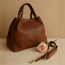 Lataa kuva Galleria-katseluun, CHIARA on näyttävä ja ajattoman tyylikäs laukku, joka on saanut inspiraationsa ikonisen Bottega Venetan designista. Aito käsin punottu intrecciato-nahka, laadukkaat yksityiskohdat ja tilava sisus tekevät siitä täydellisen arkiluksuksen ystäville.