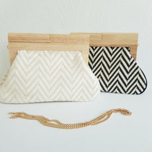 Lataa kuva Galleria-katseluun, Laukun kuviossa on siksak-kuosi, joka tuo siihen elävyyttä. Vaaleampi versio on beigen ja kullan sävyinen, kun taas tummempi on mustavalkoinen. Laukku näyttää tyylikkäältä ja sopii hyvin kesäkäyttöön.