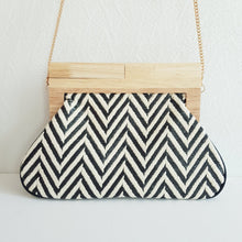 Lataa kuva Galleria-katseluun, Laukun kuviossa on siksak-kuosi, joka tuo siihen elävyyttä. Vaaleampi versio on beigen ja kullan sävyinen, kun taas tummempi on mustavalkoinen. Laukku näyttää tyylikkäältä ja sopii hyvin kesäkäyttöön.