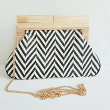 Lataa kuva Galleria-katseluun, Laukun kuviossa on siksak-kuosi, joka tuo siihen elävyyttä. Vaaleampi versio on beigen ja kullan sävyinen, kun taas tummempi on mustavalkoinen. Laukku näyttää tyylikkäältä ja sopii hyvin kesäkäyttöön.