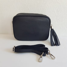 Lataa kuva Galleria-katseluun, ANGIE laukussa on kaksi säädettävää olkahihnaa ja vetoketjukiinnitys. Tupsukoriste toimii vetimenä. Erittäin suosittu crossbody malli. Laukussa yksi tasku ja pieni avotasku ja tekstiilivuorikangas. Väri: musta Materiaali nahka