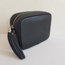 Lataa kuva Galleria-katseluun, ANGIE laukussa on kaksi säädettävää olkahihnaa ja vetoketjukiinnitys. Tupsukoriste toimii vetimenä. Erittäin suosittu crossbody malli. Laukussa yksi tasku ja pieni avotasku ja tekstiilivuorikangas. Väri: musta Materiaali nahka