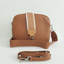 Lataa kuva Galleria-katseluun, Tyylikäs ja tilava ALEXA nahkalaukku kolmella hihnalla. Laukussa on kaksi vetoketjullista taskua ja keskellä avotasku magneettilukituksella. Väri: konjakinruskea. Koko: pituus 23 cm, korkeus 20 cm, syvyys 10 cm.
Hihnat: käsihihnan leveys 4,5 cm, pituus 61 cm, säädettävän olkahihnan leveys 1,4 cm, max pituus 113 cm
leveä koristeellinen polyesteri/nahka hihna hopeanvärisillä pistolukoilla: leveys 5,5 cm, säädettävä pituus max. 128 cm. Valmistusmaa: Italia