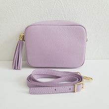 Lataa kuva Galleria-katseluun, ANGIE olkalaukku on aitoa nahkaa. Laukussa on kaksi säädettävää olkahihnaa ja vetoketjukiinnitys. Tupsukoriste toimii vetimenä. Erittäin suosittu cross body malli. Väri: lila