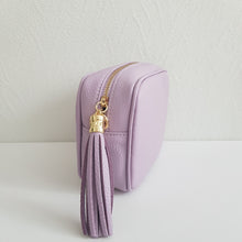 Lataa kuva Galleria-katseluun, ANGIE olkalaukku on aitoa nahkaa. Laukussa on kaksi säädettävää olkahihnaa ja vetoketjukiinnitys. Tupsukoriste toimii vetimenä. Erittäin suosittu cross body malli. Väri: lila