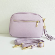 Lataa kuva Galleria-katseluun, Tyylikäs ja tilava LILY crossbody laukku on jaettu kolmeen osastoon. Jokainen osasto suljetaan vetoketjulla. Laukun takaa löytyy vetoketjullinen piilotasku ja sisällä on yksi vetoketjullinen sivutasku. Säädettävä olkahihna, kullanväriset metalliosat. Väri: vaalea lila