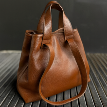 Lataa kuva Galleria-katseluun, REBECCA on monipuolinen ja supertilava shopper-nahkalaukku, jonka muoto elää mukanasi. Voit kantaa laukkua kahvoista tai olalla pitkällä hihnalla ja laukku mukautuu täydellisesti sisällön ja päivän tarpeiden mukaan. Pehmeä, laadukas nahka tekee laukusta yhtä aikaa ryhdikkään ja rennon. Vetoketju- ja magneettikiinnitys, sisällä vetoketjutasku ja avotaskut, hopeanväriset metalliosat.