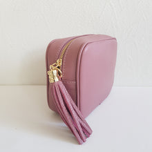 Lataa kuva Galleria-katseluun, ANGIE olkalaukku on aitoa nahkaa. Laukussa on kaksi säädettävää olkahihnaa ja vetoketjukiinnitys. Tupsukoriste toimii vetimenä. Erittäin suosittu cross body malli. Väri: roosa