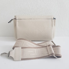 Lataa kuva Galleria-katseluun, SANDRA nahkalaukku — luonnonvalkoinen. Eleganttia käytännöllisyyttä arkeen ja juhlaan!
Sandra on italialainen nahkalaukku, joka yhdistää ajattoman tyylin ja huipputason käytännöllisyyden. Laukun moderni crossbody-malli istuu mukavasti, ja leveä, koristeellinen kangashihna tuo persoonallisen twistin – voit säätää pituuden juuri sinulle sopivaksi!