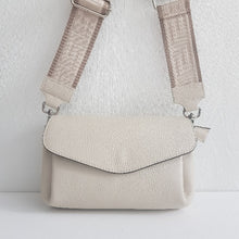 Lataa kuva Galleria-katseluun, SANDRA nahkalaukku — luonnonvalkoinen. Eleganttia käytännöllisyyttä arkeen ja juhlaan!
Sandra on italialainen nahkalaukku, joka yhdistää ajattoman tyylin ja huipputason käytännöllisyyden. Laukun moderni crossbody-malli istuu mukavasti, ja leveä, koristeellinen kangashihna tuo persoonallisen twistin – voit säätää pituuden juuri sinulle sopivaksi!