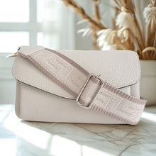 Lataa kuva Galleria-katseluun, SANDRA nahkalaukku — luonnonvalkoinen. Eleganttia käytännöllisyyttä arkeen ja juhlaan!
Sandra on italialainen nahkalaukku, joka yhdistää ajattoman tyylin ja huipputason käytännöllisyyden. Laukun moderni crossbody-malli istuu mukavasti, ja leveä, koristeellinen kangashihna tuo persoonallisen twistin – voit säätää pituuden juuri sinulle sopivaksi!