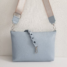 Lataa kuva Galleria-katseluun, Tyylikäs SARA nahkalaukku säädettävällä koristehihnalla ja hopeilla metalliosilla. Laukussa käsihihna on kaunista nahka punosta. Laukun sisällä löytyy vetoketjullinen sivutasku. Koko: pituus 28 cm, korkeus 20 cm, syvyys 4 cm. Hihna: leveys 3,8 cm, max pituus 126 cm. Valmistusmaa: Italia.