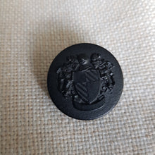 Lataa kuva Galleria-katseluun, Näyttävä muovinen metallipinnoitettu vaakunanappi kannalla, kaksi väriä: vanha kulta ja matta musta. Vaakunassa on sudet ja kilpi. Nappi sopii erityisesti klubitakkeihin, villakangastakkeihin, pitkiin neuleisiin, bleisereihin/ jakkuihin ja koristenapiksi