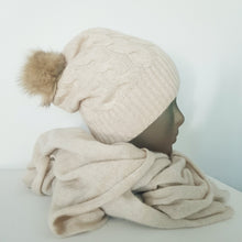 Lataa kuva Galleria-katseluun, TAIKA on upea 100 % kashmirista valmistettu palmikkoneulospipo, jota koristaa aito pörröinen tupsu. Pehmeä ja lämmin materiaali tuntuu miellyttävältä ihoa vasten, ja joustava malli takaa erinomaisen istuvuuden. Klassinen ribbineulos tekee piposta tyylikkään valinnan niin arkeen kuin juhlavampaankin talvityyliin.