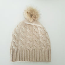 Lataa kuva Galleria-katseluun, TAIKA on upea 100 % kashmirista valmistettu palmikkoneulospipo, jota koristaa aito pörröinen tupsu. Pehmeä ja lämmin materiaali tuntuu miellyttävältä ihoa vasten, ja joustava malli takaa erinomaisen istuvuuden. Klassinen ribbineulos tekee piposta tyylikkään valinnan niin arkeen kuin juhlavampaankin talvityyliin.