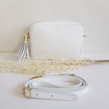 Lataa kuva Galleria-katseluun, ANGIE olkalaukussa on kaksi säädettävää olkahihnaa ja vetoketjukiinnitys. Tupsukoriste toimii vetimenä. Erittäin suosittu crossbody malli. Materiaali: aitoa nahkaa Väri: valkoinen Koko: pituus 20 cm, korkeus 15 cm, syvyys 7 cm. Laukkuun kuuluu kaksi säädettävää olkahihnaa: kapea nahkahihna kullanvärisillä pistolukoilla, leveys 2 cm, säädettävä pituus 128 cm leveä koristeellinen polyesteri/nahka hihna kullanvärisillä pistolukoilla, leveys 5,5 cm, säädettävä pituus max. 128 cm