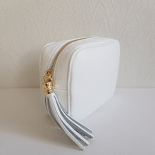 Lataa kuva Galleria-katseluun, ANGIE olkalaukussa on kaksi säädettävää olkahihnaa ja vetoketjukiinnitys. Tupsukoriste toimii vetimenä. Erittäin suosittu crossbody malli. Materiaali: aitoa nahkaa Väri: valkoinen Koko: pituus 20 cm, korkeus 15 cm, syvyys 7 cm. Laukkuun kuuluu kaksi säädettävää olkahihnaa: kapea nahkahihna kullanvärisillä pistolukoilla, leveys 2 cm, säädettävä pituus 128 cm leveä koristeellinen polyesteri/nahka hihna kullanvärisillä pistolukoilla, leveys 5,5 cm, säädettävä pituus max. 128 cm