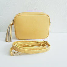 Lataa kuva Galleria-katseluun, ANGIE laukussa on kaksi säädettävää olkahihnaa ja vetoketjukiinnitys. Tupsukoriste toimii vetimenä. Erittäin suosittu crossbody malli. Väri: keltainen