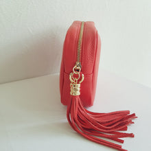 Lataa kuva Galleria-katseluun, ANGIE olkalaukku on aitoa nahkaa. Laukussa on säädettävä olkahihna, vetoketjukiinnitys. Tupsukoriste toimii vetimenä. Valmistettu Italiassa, erittäin suosittu cross body malli. Väri: oranssinpunainen Koko: pituus 20 cm, korkeus 15 cm, syvyys 7 cm. Olkahihnan pituus 130 cm. Hoito-ohje: Voi suojata nahalle sopivalla suojausaineella ennen käyttöönottoa. Puhdistetaan kostealla liinalla. Valmistusmaa Italia