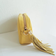 Lataa kuva Galleria-katseluun, ANGIE olkalaukku on aitoa nahkaa. Laukussa on säädettävä olkahihna, vetoketjukiinnitys. Tupsukoriste toimii vetimenä. Valmistettu Italiassa, erittäin suosittu cross body malli. Väri: keltainen Koko: pituus 20 cm, korkeus 15 cm, syvyys 7 cm. Olkahihnan pituus 130 cm. Hoito-ohje: Voi suojata nahalle sopivalla suojausaineella ennen käyttöönottoa. Puhdistetaan kostealla liinalla.