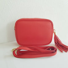 Lataa kuva Galleria-katseluun, ANGIE olkalaukku on aitoa nahkaa. Laukussa on säädettävä olkahihna, vetoketjukiinnitys. Tupsukoriste toimii vetimenä. Valmistettu Italiassa, erittäin suosittu cross body malli. Väri: oranssinpunainen Koko: pituus 20 cm, korkeus 15 cm, syvyys 7 cm. Olkahihnan pituus 130 cm. Hoito-ohje: Voi suojata nahalle sopivalla suojausaineella ennen käyttöönottoa. Puhdistetaan kostealla liinalla. Valmistusmaa Italia