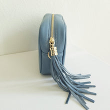 Lataa kuva Galleria-katseluun, ANGIE olkalaukku on aitoa nahkaa. Väri: harmaansininen Koko: pituus 20 cm, korkeus 15 cm, syvyys 7 cm. Laukkuun kuulu kaksi säädettävää olkahihnaa: kapea nahkahihna kullanvärisillä pistolukoilla, leveys 2 cm, säädettävä pituus 130 cm leveä koristeellinen polyesteri/ nahka hihna kullanvärisillä pistolukoilla, leveys 5,5 cm, säädettävä pituus max. 128 cm Hoito-ohje: Voi suojata nahalle sopivalla suojausaineella ennen käyttöönottoa. Puhdistetaan kostealla liinalla.