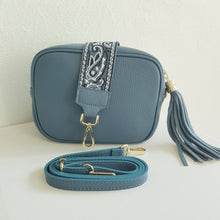 Lataa kuva Galleria-katseluun, ANGIE olkalaukku on aitoa nahkaa. Väri: harmaansininen Koko: pituus 20 cm, korkeus 15 cm, syvyys 7 cm. Laukkuun kuulu kaksi säädettävää olkahihnaa: kapea nahkahihna kullanvärisillä pistolukoilla, leveys 2 cm, säädettävä pituus 130 cm leveä koristeellinen polyesteri/ nahka hihna kullanvärisillä pistolukoilla, leveys 5,5 cm, säädettävä pituus max. 128 cm Hoito-ohje: Voi suojata nahalle sopivalla suojausaineella ennen käyttöönottoa. Puhdistetaan kostealla liinalla.