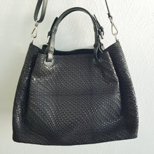 Lataa kuva Galleria-katseluun, Upea CHIARA laukku on tunnetun Bottega Veneta brändin inspiroima malli. Tyylikäs ja tilava laukku on valmistettu aidosta intrecciato punotusta nahasta. Sisällä on vetoketjullinen tilanjakaja sekä vetoketjullinen sivutasku ja avotasku. Väri: musta Kantokahvat ja olkahihna voi säätää. Koko: korkeus 32 cm, leveys 50 cm, syvyys 19 cm Olkahihnan koko: leveys 2 cm, max pituus 125 cm Valmistettu Italiassa.