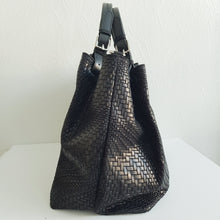 Lataa kuva Galleria-katseluun, Upea CHIARA laukku on tunnetun Bottega Veneta brändin inspiroima malli. Tyylikäs ja tilava laukku on valmistettu aidosta intrecciato punotusta nahasta. Sisällä on vetoketjullinen tilanjakaja sekä vetoketjullinen sivutasku ja avotasku. Väri: musta Kantokahvat ja olkahihna voi säätää. Koko: korkeus 32 cm, leveys 50 cm, syvyys 19 cm Olkahihnan koko: leveys 2 cm, max pituus 125 cm Valmistettu Italiassa.