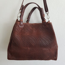 Lataa kuva Galleria-katseluun, Upea CHIARA laukku on tunnetun Bottega Veneta brändin inspiroima malli. Tyylikäs ja tilava laukku on valmistettu aidosta intrecciato punotusta nahasta. Sisällä on vetoketjullinen tilanjakaja sekä vetoketjullinen sivutasku sekä avotasku Väri: ruskea Kantokahvat ja olkahihna on säädettävät. Koko: korkeus 32 cm, leveys 50 cm, syvyys 19 cm Olkahihnan koko: leveys 2 cm, max pituus 125 cm Valmistettu Italiassa.