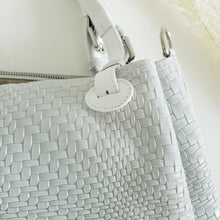 Lataa kuva Galleria-katseluun, Upea CHIARA laukku on tunnetun Bottega Veneta brändin inspiroima malli. Tyylikäs ja tilava laukku on valmistettu aidosta intrecciato punotusta nahasta. Sisällä on vetoketjullinen tilanjakaja sekä vetoketjullinen sivutasku sekä avotasku. Väri: valkoinen Kantokahvat ja olkahihna on säädettävät. Koko: korkeus 32 cm, leveys 50 cm, syvyys 19 cm Olkahihnan koko: leveys 2 cm, max pituus 125 cm Valmistettu Italiassa.