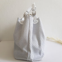 Lataa kuva Galleria-katseluun, Upea CHIARA laukku on tunnetun Bottega Veneta brändin inspiroima malli. Tyylikäs ja tilava laukku on valmistettu aidosta intrecciato punotusta nahasta. Sisällä on vetoketjullinen tilanjakaja sekä vetoketjullinen sivutasku sekä avotasku. Väri: valkoinen Kantokahvat ja olkahihna on säädettävät. Koko: korkeus 32 cm, leveys 50 cm, syvyys 19 cm Olkahihnan koko: leveys 2 cm, max pituus 125 cm Valmistettu Italiassa.