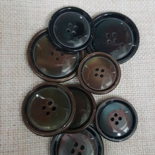 Lataa kuva Galleria-katseluun, Klassinen nelireikäinen läpiommeltava polyesterinappi. Laadukas polyesterimateriaali antaa kauniin helmiäiskiillon nappipinnalle. Kevyt, 4 mm paksuinen, koot 25 mm, 27 mm, 30 mm, 34 mm. Sopii mainiosti miesten ja naisten pikkutakkeihin, villakangastakkeihin ja neuleisiin. Värit helmiäisharmaa ja helmiäisruskea.